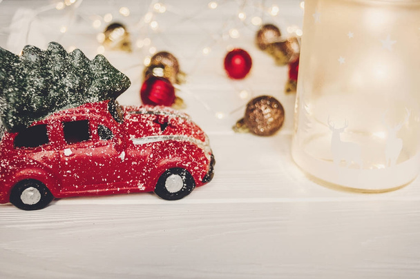 juguete de coche rojo con árbol de Navidad en la parte superior y linterna con ciervos
  - Foto, imagen