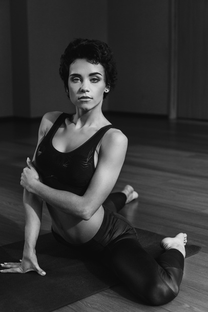 Vrouw zittend op yoga mat - Foto, afbeelding