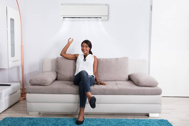 Woman Using Air Conditioner  - Fotó, kép