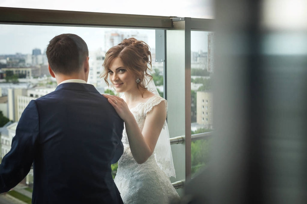 beautiful newlywed couple near window with city landscape - Fotoğraf, Görsel