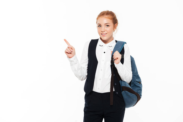 Smiling gigner student woman with backpack pointing up - Foto, Imagem