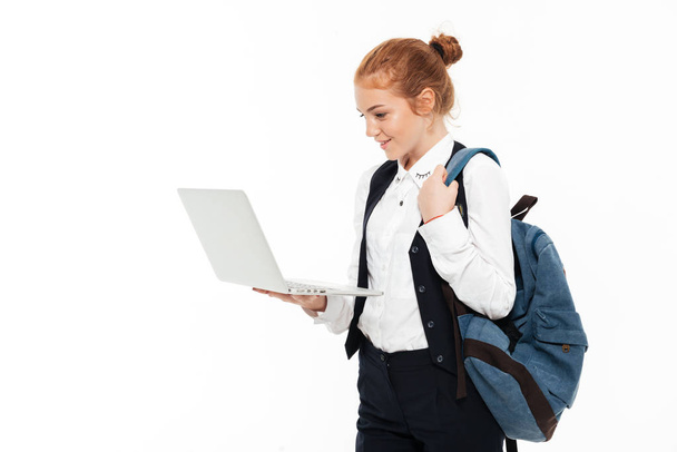 Happy gigner student woman with backpack holding laptop computer - Foto, afbeelding