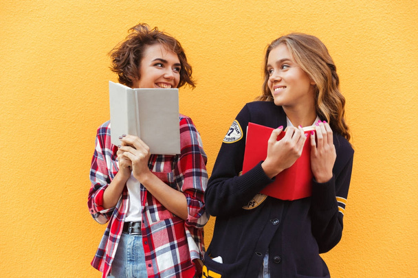Portrait of two happy pretty teenage girl with books - Foto, Imagem
