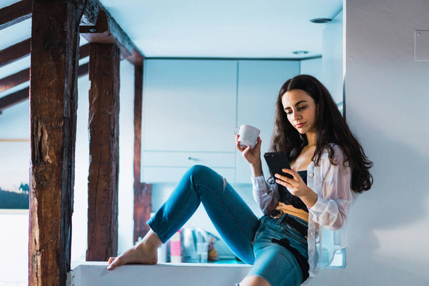 Woman relaxing with phone in morning - Фото, зображення