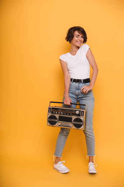 Full length portrait of a young girl holding record player - Foto, Bild