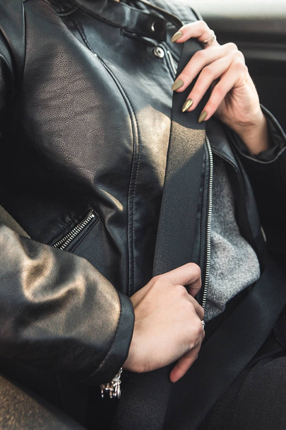 Immagine ritagliata di ragazza che fissa una cintura di sicurezza durante la guida di una macchina
 - Foto, immagini