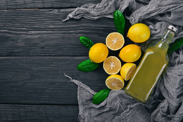 Tequila, fresh lemon and lemon juice. On a wooden background. Top view. Free space for your text. - Foto, Imagem