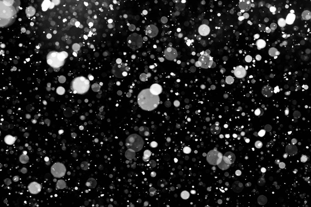Falling snow on black background. - Foto, afbeelding