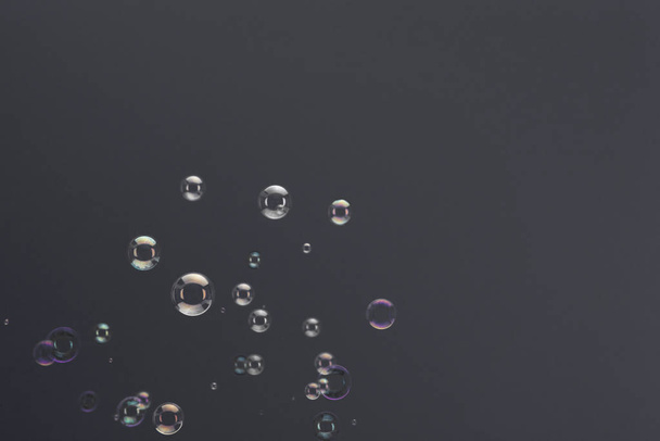 Stijgende zeepbellen op een grijze achtergrond - Foto, afbeelding