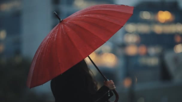 Happy woman under red umbrella walking in downtown - Filmati, video