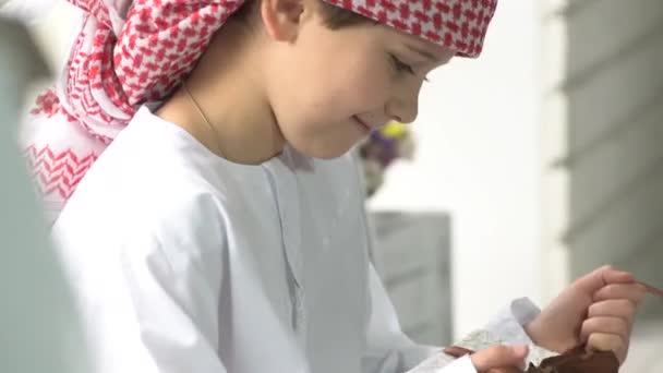 Roztomilé arabské chlapeček rozbalí dárek. - Záběry, video