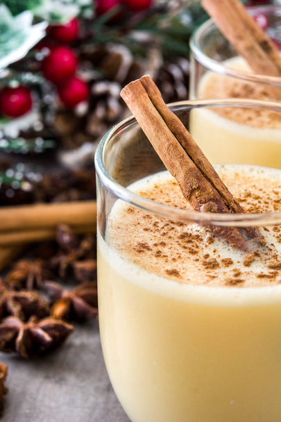 Homemade eggnog with cinnamon on wooden table. Typical Christmas dessert. - Photo, image
