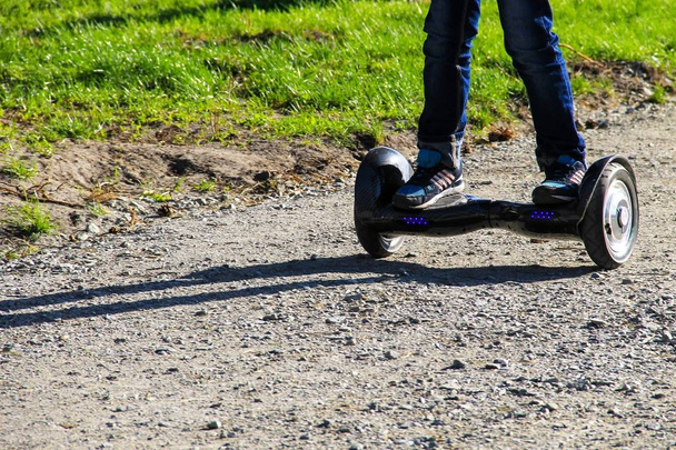Nogi chłopca jazda na samoorganizującego się mini hoverboard w mieście - Zdjęcie, obraz