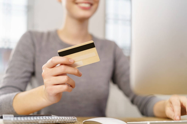 Woman contemplating making credit purchase - Фото, изображение
