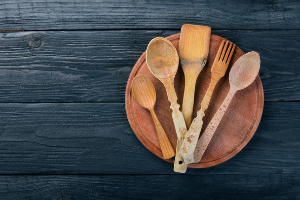 Wooden spoons, forks and shovels. On a wooden background. Top view. Free space for your text. - Фото, зображення