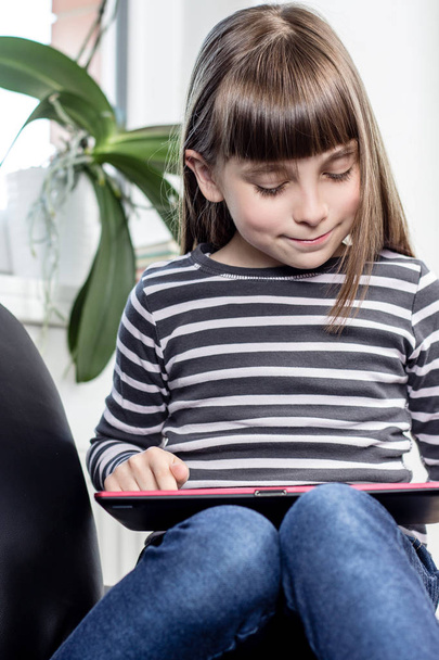 Little girl playing on digital tablet - Fotó, kép