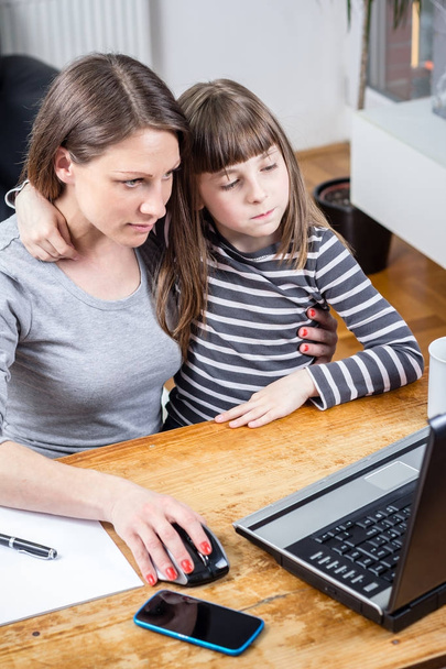 Photo of young business female with daughter working at home - Fotoğraf, Görsel