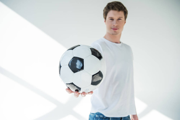 Νεαρός άνδρας με μπάλα ποδοσφαίρου - Φωτογραφία, εικόνα