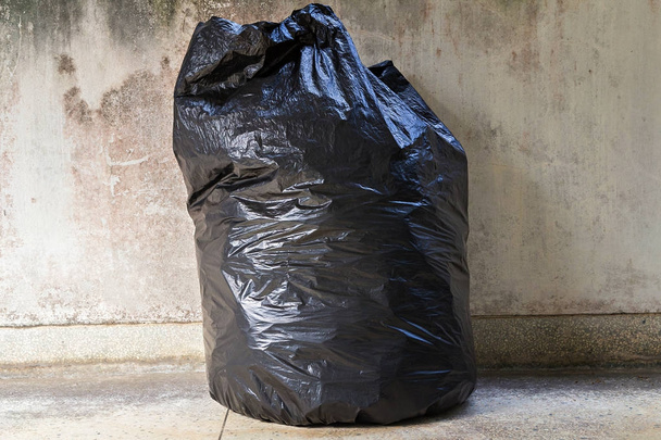 Nahaufnahme eines vollen Müllsacks auf dem Fußboden - Foto, Bild