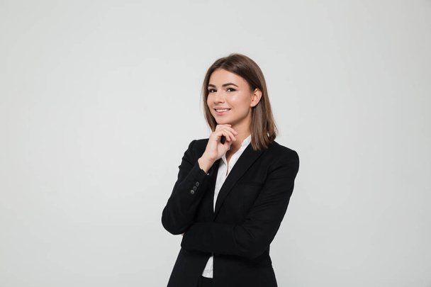 Portrait of young brown-haired businesswoman in suit - Fotó, kép