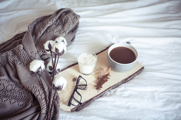 Herfst gezellig ontbijt op bed. Romantische ontbijt. Katoen, een kopje warme koffie, een kaars. Herfst gezelligheid. Een lade met ontbijt is op het bed. Val. - Foto, afbeelding