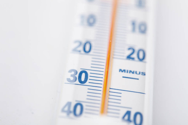 Термометр с шкалой Цельсия на белом фоне крупным планом
 - Фото, изображение