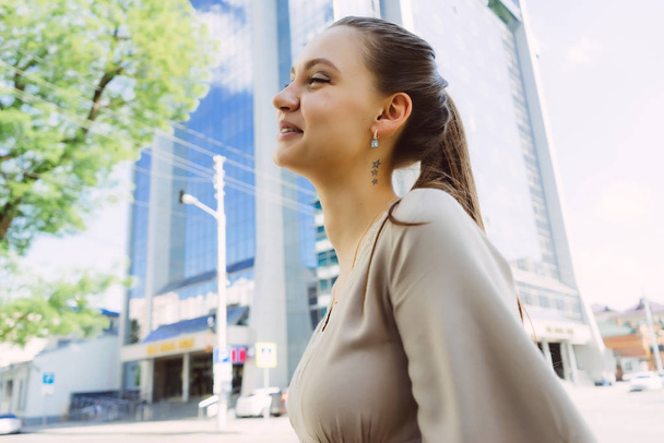 beautiful laughing girl in beige dress walking around the city - Foto, immagini