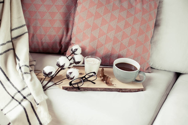 Desayuno acogedor de otoño. Desayuno romántico. Algodón, una taza de café caliente, una vela, una manta a cuadros, vasos. Confort otoñal. Una bandeja con
 - Foto, Imagen