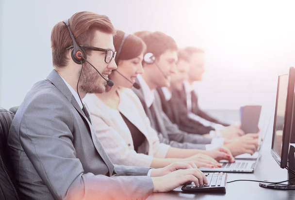 operators with headsets in front of computers in the call center - Photo, image