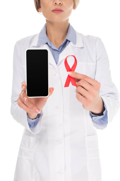 doctor with smartphone and aids ribbon - Photo, Image
