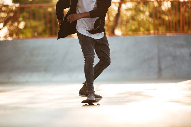 Cropped image of an african skateboarder skating - Photo, Image