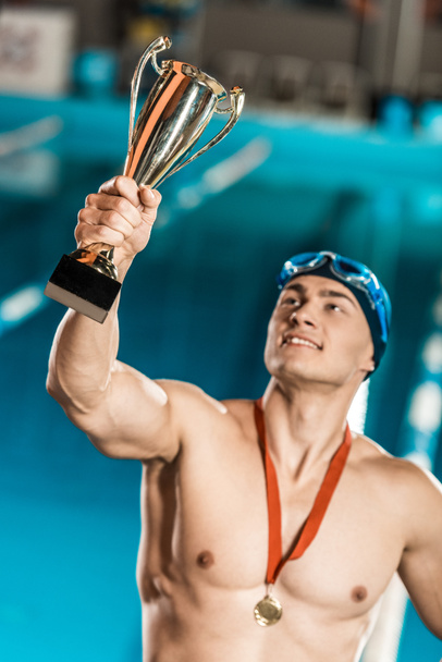 χαμογελώντας κολυμβητής κρατώντας Κύπελλο τρόπαιο - Φωτογραφία, εικόνα