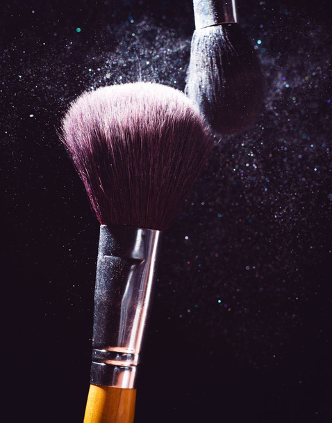 Косметическая кисть и взрыв красочный макияж фоне порошка
 - Фото, изображение
