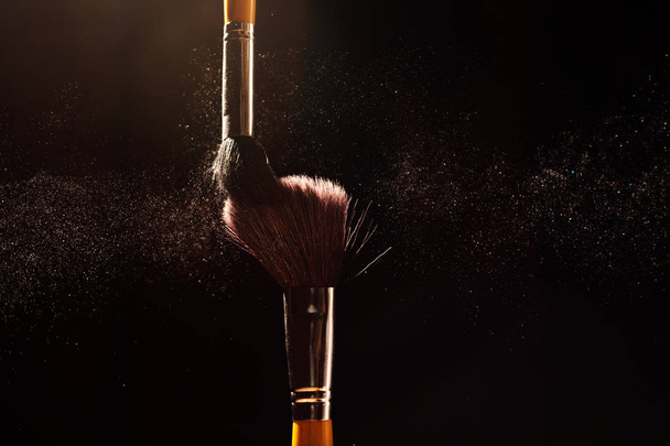 Cosmetics brush and explosion colorful makeup powder background - Foto, imagen