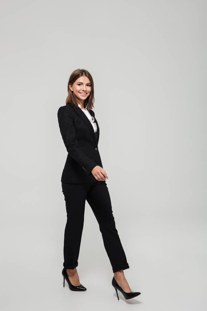 Full length portrait of a smiling beautiful woman in suit - Photo, Image