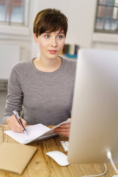 Young woman sitting in front of computer  - Foto, Imagen