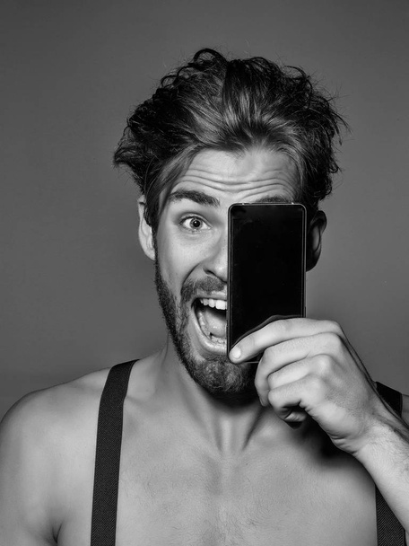 Excited handsome man with smartphone - 写真・画像