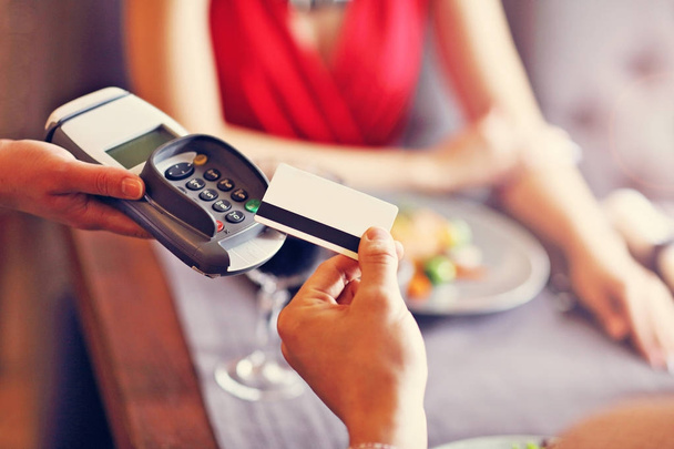 Personnes payant au restaurant par lecteur de carte de crédit
 - Photo, image