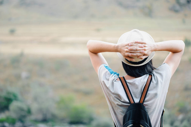 Back view of the young woman wearing hat looking at landscape - Фото, изображение
