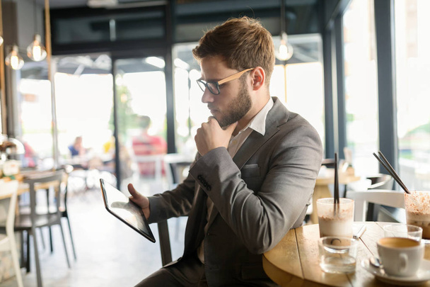 Businessman using tablet in cafe - Фото, изображение