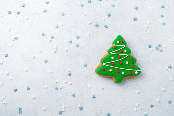 Gingerbread in the form of Christmas trees and confectioner's multicolored powder on light stone or concrete background. - Photo, Image