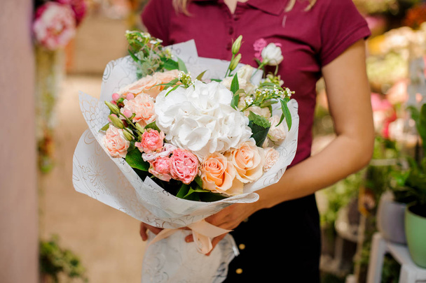 Lovely tender bouquet of various flowers in woman hands - Foto, afbeelding
