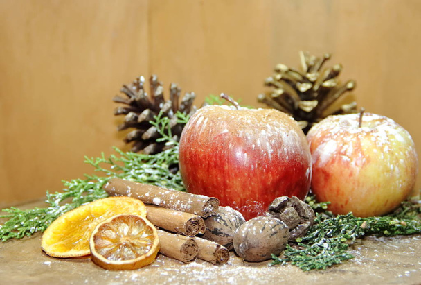 christmas background red apples golden pineapples green pines and dried fruit - Photo, Image