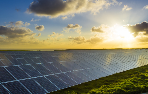 Sonnenkollektoren bei Sonnenaufgang mit bewölktem Himmel in der Normandie, Frankreich. Solarenergie, moderne Stromerzeugungstechnologie, Konzept für erneuerbare Energien. umweltfreundliche Stromerzeugung - Foto, Bild