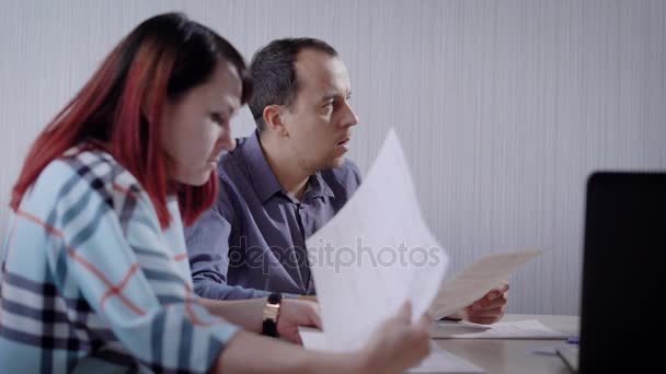 hombre y mujer son clientes de una empresa de bienes raíces están sentados en un departamento de servicio al cliente y la lectura de papeles
 - Imágenes, Vídeo