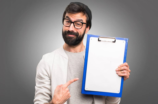 Happy Hipster man with folder on grey background - Photo, Image
