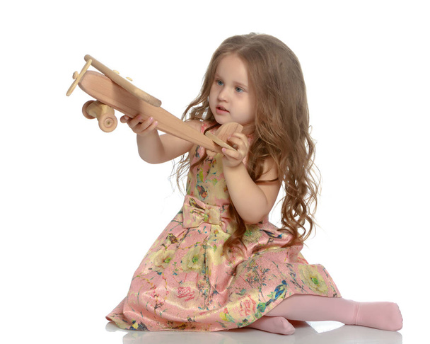 Little girl is playing with a plane - Zdjęcie, obraz