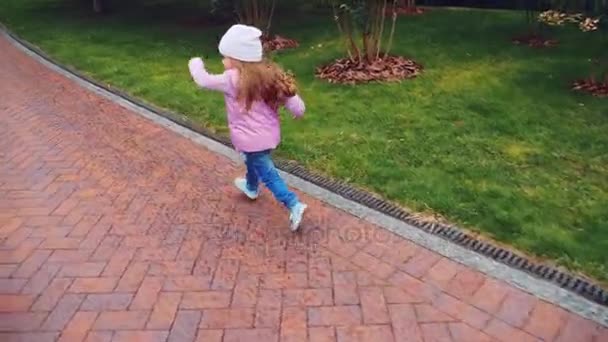 Charming little girl runs along the path - Filmati, video