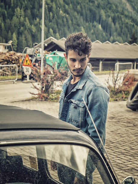 Young man looking at vintage car - Photo, Image
