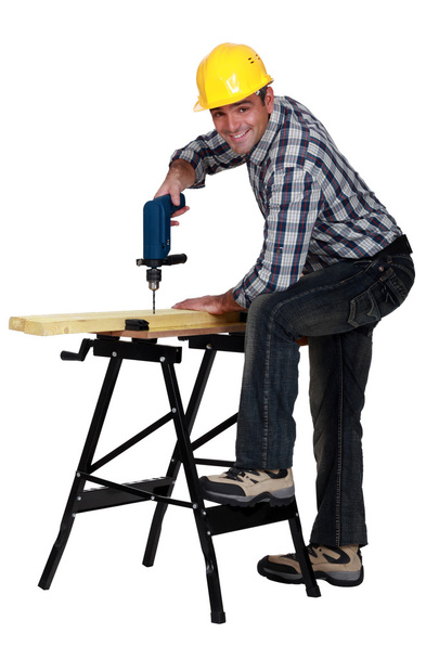 Man using a drill at a workbench - Фото, зображення